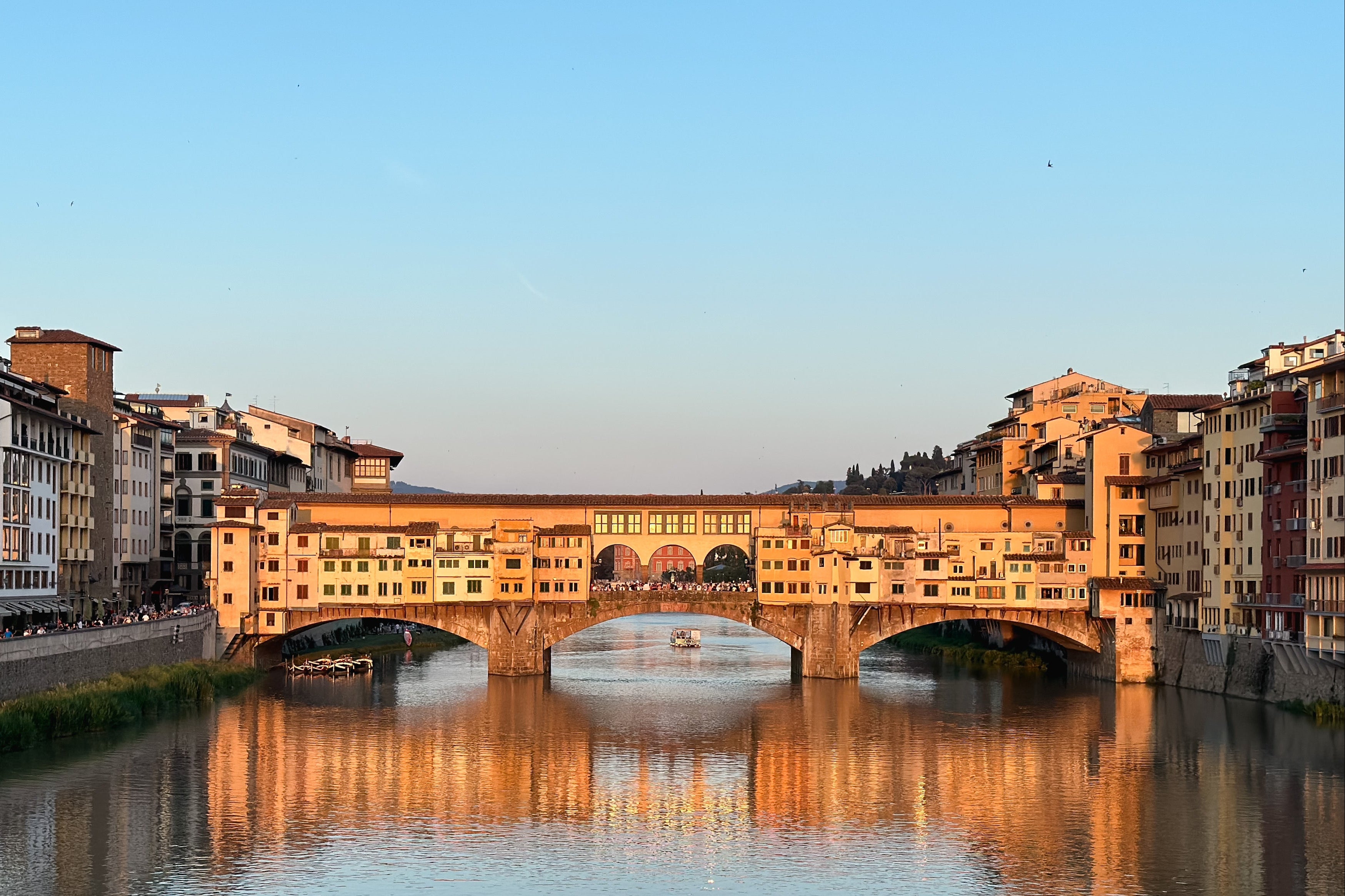 Florence Old Bridge over Arno river with buildings on either side at sunset